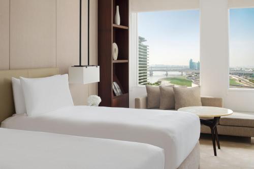 迪拜迪拜节日城洲际酒店的卧室配有白色的床、沙发和窗户。