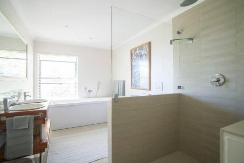 开普敦APARTMENT ON CONSTANTIA WINE ROUTE的白色的浴室设有浴缸和水槽。
