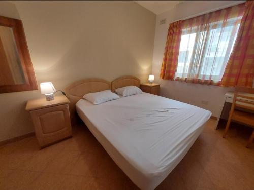 比尔基卡拉Private room in Shared apartment close to University of Malta & Mater Dei的一间卧室配有带2个床头柜和1扇窗户的床