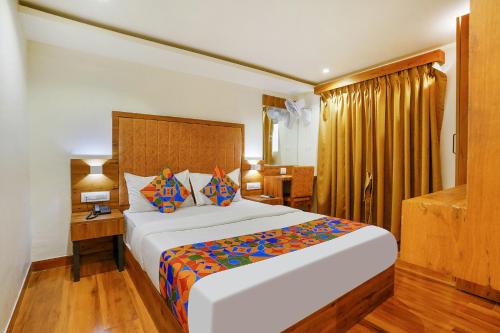 孟买FabHotel Royal Palace I的酒店客房配有一张床、一张书桌和一张四柱床