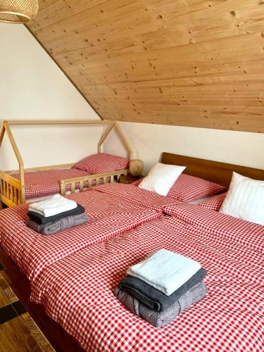 斯塔拉·里斯拉Chata pod horou的配有红色和白色床单的客房内的两张床