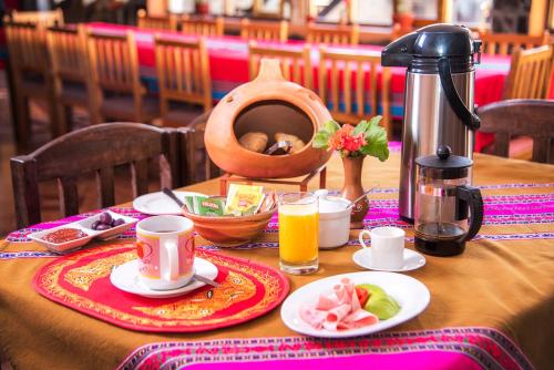 YanqueSumaq Wayra的一张桌子,早餐包括咖啡和橙汁