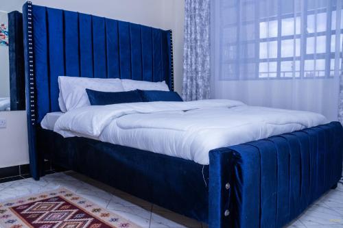 纳纽基Tiny Haven executive one bedroom with Private Balcony的卧室内的一张带蓝色床头板的大床