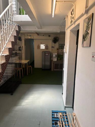 马六甲SPOT ON 90898 Kasturi Alley Guest House & Cat Hotel的客房设有厨房和带冰箱的楼梯。