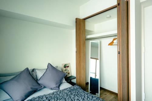 东京Home n Lounge的一间卧室配有一张床和镜子