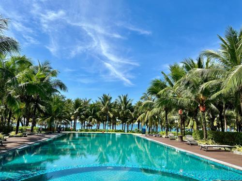 富国West Phu Quoc 3BR beach villa private swimming pool的棕榈树和蓝天的游泳池