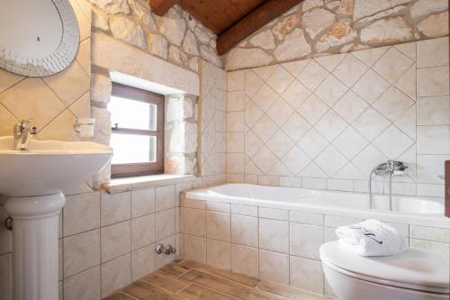 Agios LeonVilla Boscheto Tria的一间带水槽、浴缸和卫生间的浴室