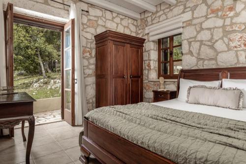Agios LeonVilla Boscheto Tria的一间卧室设有一张床和石墙
