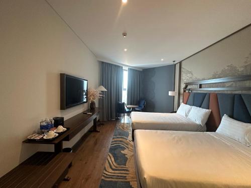 美奈Apec Mandala Mũi Né Condotel By Vũ的酒店客房设有两张床和一台平面电视。
