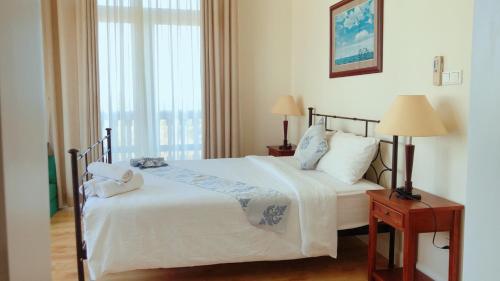 Ấp Bình HưngSealink Beach Villa PE48- PE69的一间卧室配有一张带两盏灯的床和一扇窗户。