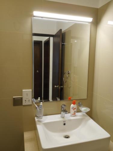 尼甘布OCEAN BREEZE - WAVES LUXURY CONDO的浴室设有白色水槽和镜子