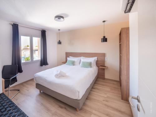 VinzellesLe Mâconnais Guest House的卧室配有一张白色大床和一把椅子