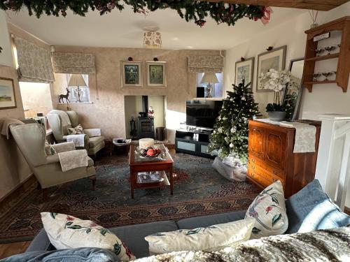 泰特伯里Turnpike Cottage的客厅配有圣诞树和沙发