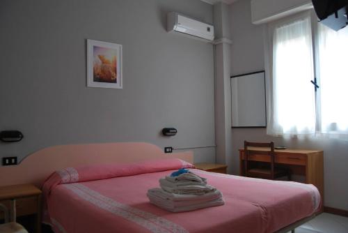里米尼Hotel Laura Beach的一间卧室配有一张带粉色床单的床和一扇窗户。