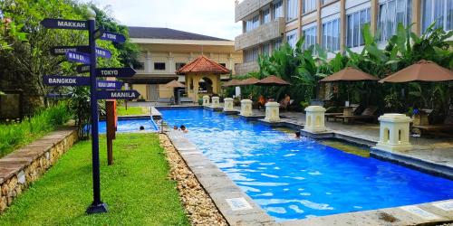 武吉丁宜TripleTree Hotel And Resort Bukittinggi的酒店内有路标的游泳池