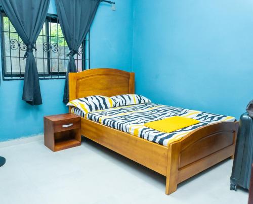 林贝Vyemma Residence的一间卧室配有一张带蓝色墙壁的木床