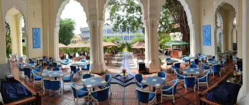 武吉丁宜TripleTree Hotel And Resort Bukittinggi的大楼内带桌椅的房间
