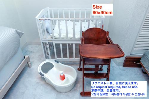 读谷村Yomitan kuba house的一张带椅子和婴儿座椅的婴儿床
