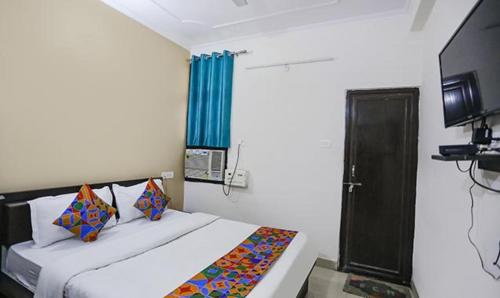 KakarmathaFabHotel Lily Grand的一间卧室配有一张蓝色窗帘的床