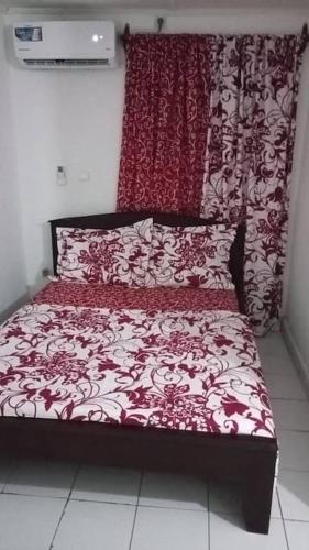 杜阿拉Résidences Lili的客房内的一张红色和白色的床