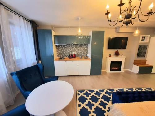 锡纳亚Romantic Jacuzzi Luxury Apartment的客厅设有厨房、桌子和客厅。