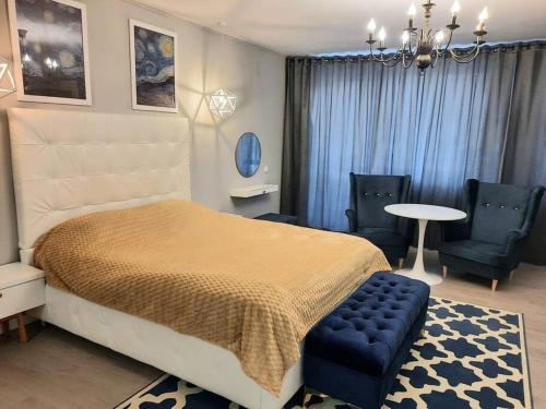 锡纳亚Romantic Jacuzzi Luxury Apartment的卧室配有一张床和一张桌子及椅子