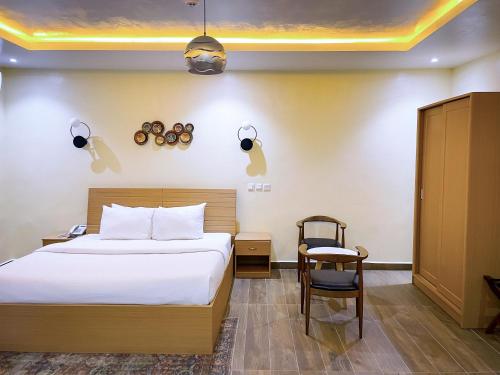 阿布贾Address hotels and towers的配有一张床和一把椅子的酒店客房