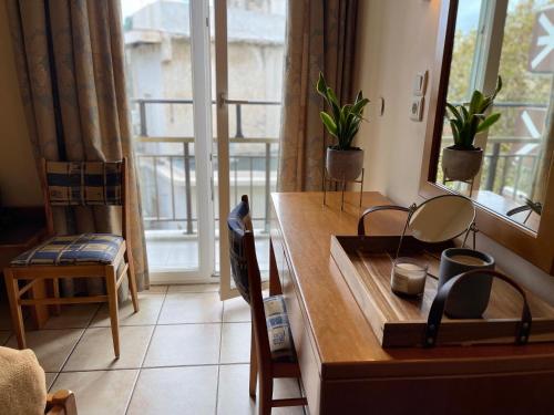 海若克利欧格列柯酒店 的客房设有书桌和植物窗户