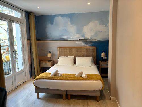 圣让-德吕兹Mosaikhotel的一间卧室配有一张床,上面有两条毛巾