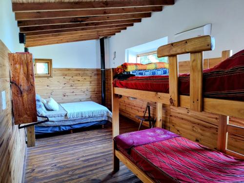 圣卡洛斯-德巴里洛切Cabaña de montaña Ruca Calel的小屋内设有一间带两张双层床的卧室