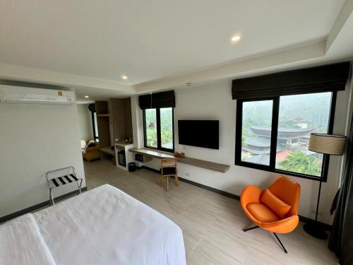 奥南海滩Keereen Resort - Ao Nang Krabi的一间卧室配有一张床、一台电视和一把椅子