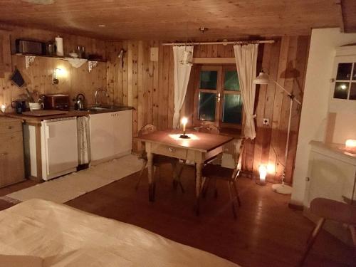 沃瑟姆阿尔伯格Älpler Stuba Appartements am Lärchenhof的厨房配有一张桌子和两把蜡烛