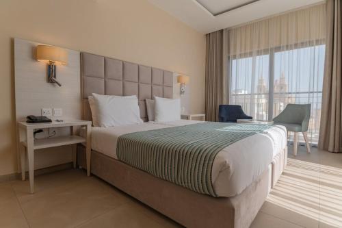 梅利哈玛丽蒂姆马耳他酒店的一间设有大床和窗户的酒店客房