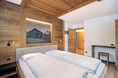 塞尔瓦迪加尔代纳山谷Tinahof的卧室配有一张床铺,位于带木墙的房间内