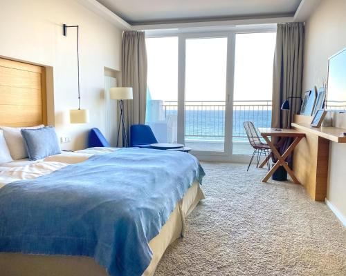 蒂门多弗施特兰德SeeHuus Lifestyle Hotel的酒店客房设有一张床、一张书桌和窗户。