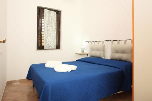 圣维托罗卡波Acquamarina32的一间卧室,在蓝色的床上配有2条毛巾
