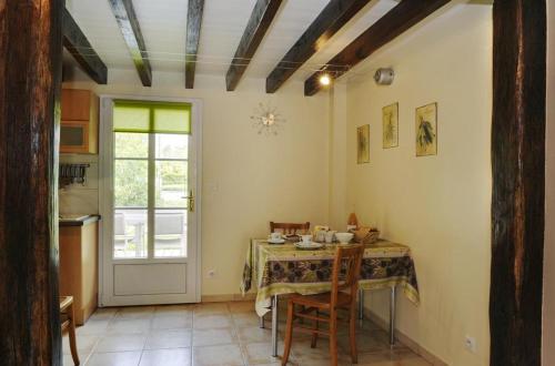 Rosnay-lʼHôpitalLe petit pre des marguerites的厨房配有桌椅和窗户。
