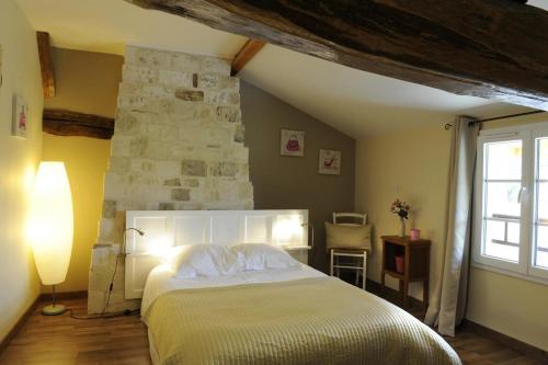 Rosnay-lʼHôpitalLe petit pre des marguerites的一间卧室设有一张大床和石墙