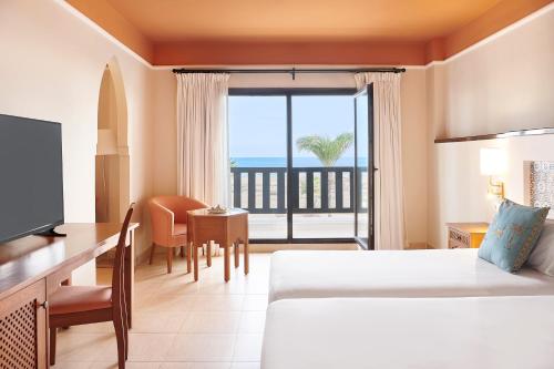 萨伊迪耶伊波罗之星度假酒店的配有一张床、一张书桌和一扇窗户的酒店客房