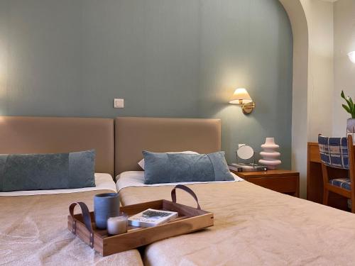 海若克利欧格列柯酒店 的一间卧室配有两张床,床上有一个托盘
