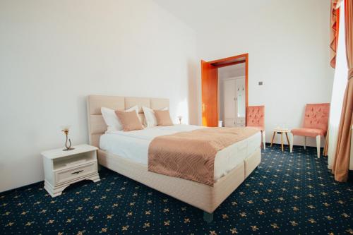 瓦特拉多尔内卡罗尔酒店 - 瓦特拉多尔奈的卧室配有1张床、1张桌子和1把椅子