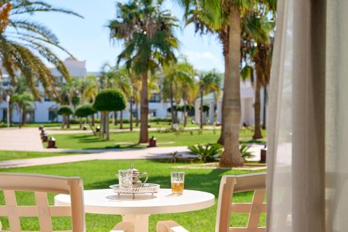 萨伊迪耶伊波罗之星度假酒店的坐在公园顶部的桌子上,放着一杯葡萄酒