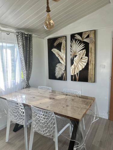 SERRA DI FIUMORBOles bungalows de Lisa Maria的餐桌、椅子和墙上的绘画