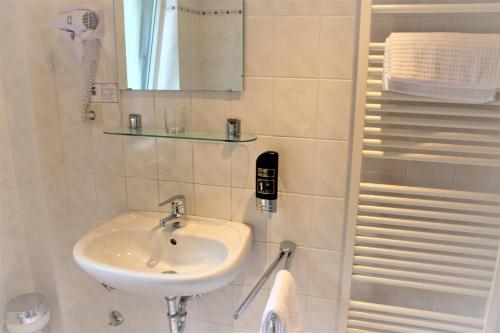 亨施泰特-乌尔茨堡Apartment Hotel的一间带水槽和镜子的浴室