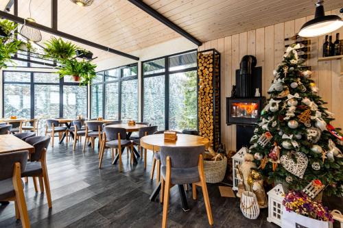 布克维Шишка的餐厅的圣诞树,配有桌椅