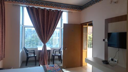斋浦尔Hotel Braj Haveli的客房设有带椅子和桌子的窗户。