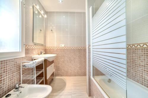 卡尔佩Bungalow Rosa - PlusHolidays的浴室配有水槽、淋浴和浴缸。