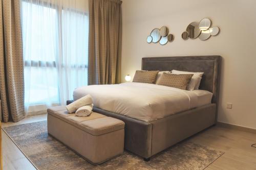 迪拜New 2 bedroom entire apartment in Madinat Jumeirah Living的一间卧室配有一张大床和一张搁脚凳