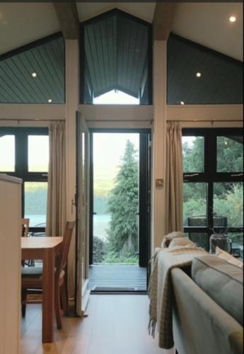MorenishEllesmere Lodge的一间卧室配有一张床、一张桌子和一个大窗户