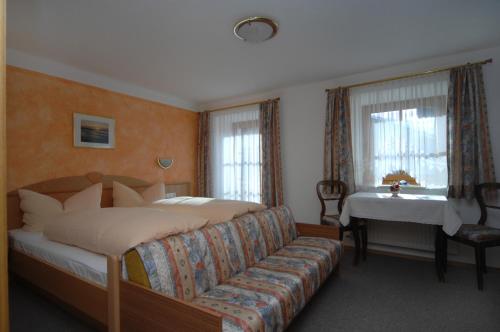 上蒂利拉赫纳芙勒霍夫酒店的一间卧室配有一张床、一张沙发和一张桌子